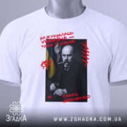 Футболка Тарас Шевченко подарунок, біла футболка з принтом, зображення Тараса Шевченка на чорному фоні, червоний текст з написом 'Зажурилась Україна – така її доля!', ракурс зверху, на футболці зелений ярлик.