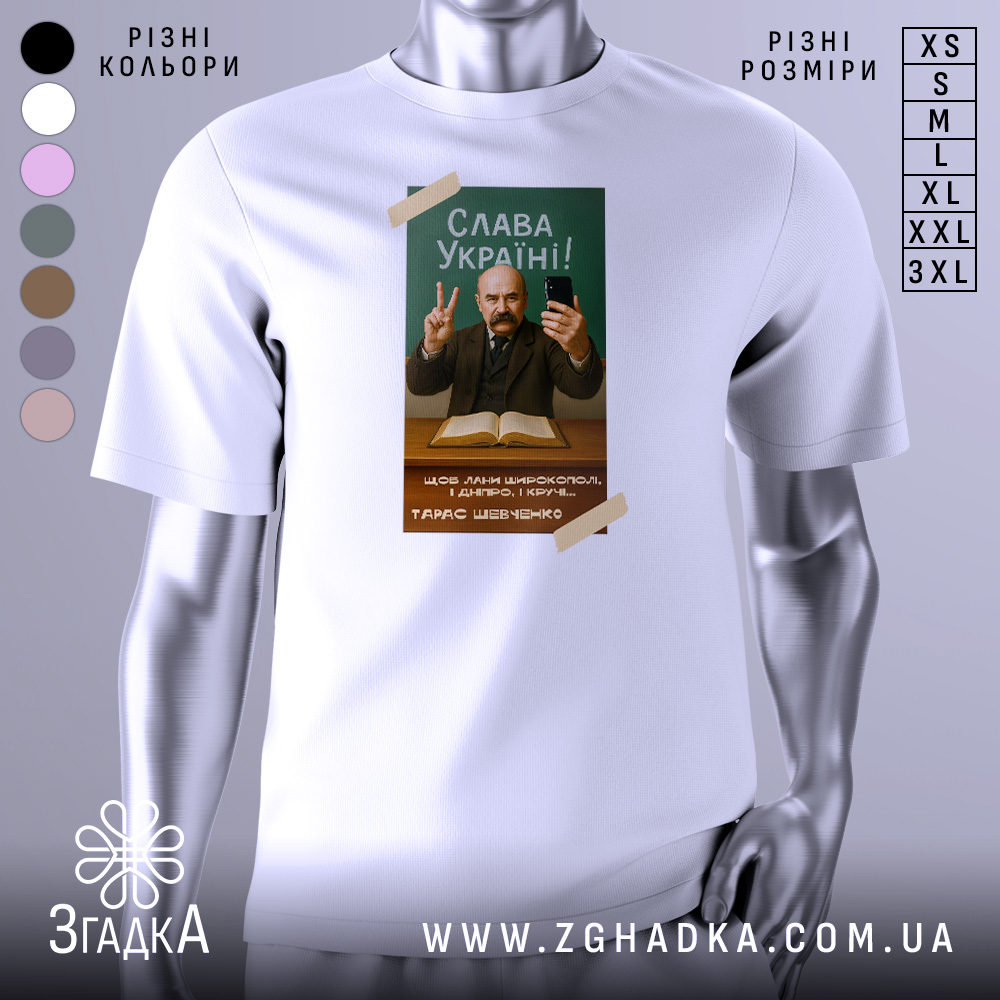 Футболка Тарас Шевченко селфі, біла, зображена в анфас, фон нейтральний, принт з портретом Тараса Шевченка, він тримає телефон і показує знак миру, текст "Слава Україні!" на зеленому фоні.