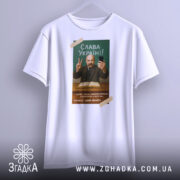 Футболка Тарас Шевченко селфі, біла, зображена в анфас, фон світло-сірий, принт з портретом Тараса Шевченка, він тримає телефон і показує знак миру, текст "Слава Україні!" на зеленому фоні.