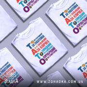 Футболка тато герой для дітей, біла, зображена з фронтального ракурсу на манекені, фон світло-сірий, принт кольоровий з текстом "ТАТО" та різними іконками, що підкреслюють його значення.