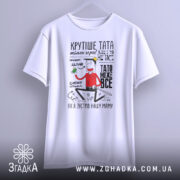 Футболка тато може все, біла, підвішена на вішалці, фон світло-сірий, принт з веселим персонажем, текст на футболці чіткий і виразний.