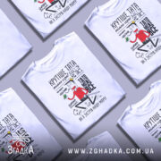 Футболка тато може все, біла, зображена на манекені, фон нейтральний, принт з веселим персонажем у червоній сорочці, текст українською мовою, що підкреслює позитивні якості тата.