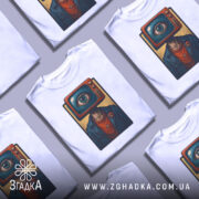 Футболка телевізор око, біла, зображена на манекені, ракурс спереду, фон світло-сірий, принт з телевізором і оком на голові персонажа в синій куртці.