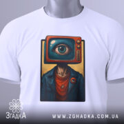 Футболка телевізор око, біла, зображена зверху, фон світло-сірий, принт з телевізором і оком на голові персонажа, прикріплена етикетка з зеленим шнурком.