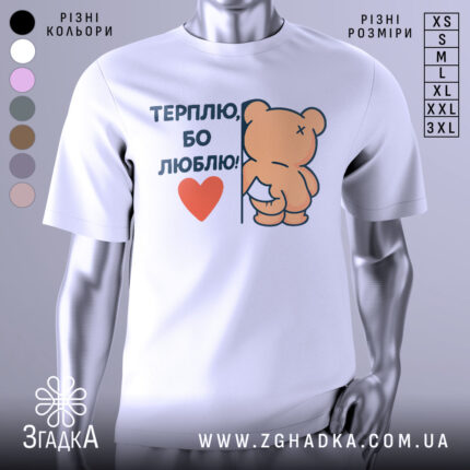 Футболка терплю люблю, білого кольору, зображена на манекені з легким боковим ракурсом, фон світло-сірий, принт з ведмедиком, що тримається за стіну, з написом 'ТЕРПЛЮ, БО ЛЮБЛЮ!' і червоним сердечком.