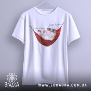 Футболка тяжко жити, біла, підвішена на вішалці, фон світло-сірий, принт з котом у окулярах, що лежить у гамаку, з написом 'Тяжко жити' і 'Шкода вмерти'.