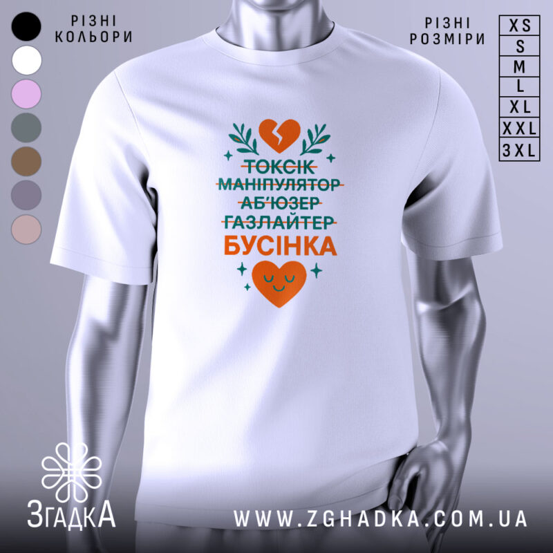 Футболка токсік бусінка, біла, зображена на манекені, фон градієнтний сірий, принт містить текст у зеленому та оранжевому кольорах, з серцем та рослинними елементами.