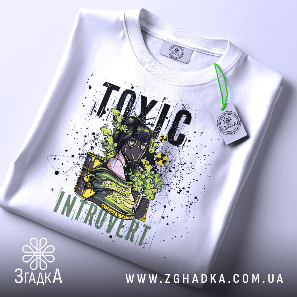 Футболка токсичний інтроверт, білого кольору, зображена на столі з верхнього ракурсу, фон світло-сірий, принт з дівчиною в протигазі, текст 'TOXIC INTRUVERT' в чорному та зеленому кольорах, на футболці є етикетка з зеленим шнурком.