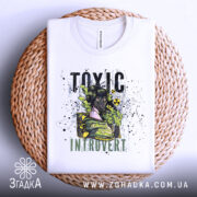 Футболка токсичний інтроверт, білого кольору, зображена на плетеній основі, фон світло-сірий, принт з дівчиною в протигазі, текст 'TOXIC INTRUVERT' в чорному та зеленому кольорах, видно шви та комір.