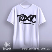 Футболка токсичний подарунок, біла, підвішена на вішалці, фон світло-сірий, принт чорний з написом 'TOXIC' у стилі графіті.