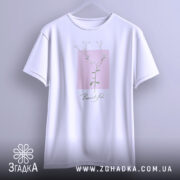 Футболка тонка ботаніка білого кольору, підвішена на вішалці, зображена з фронтального ракурсу, фон світло-сірий, принт з квітковим мотивом на рожевому квадраті з написом 'Beautiful' під ним.