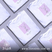 Футболка тонка ботаніка білого кольору, зображена з фронтального ракурсу на манекені, фон світло-сірий, принт з квітковим мотивом на рожевому квадраті з написом 'Beautiful' під ним.