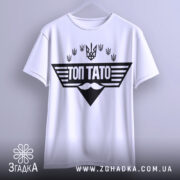 Футболка топ тато білого кольору, підвішена на вішалці, фон світлий, принт чорного кольору з написом 'ТОП ТАТО' та символікою України.