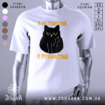 Футболка товстий пухнастий, біла, зображена з фронтального ракурсу, на фоні світло-сірого кольору, принт з чорним котом з жовтими очима та текстом "Я не товстий, я пухнастий" у жовтому кольорі.