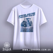 Футболка трактор у полі, біла, зображена спереду на манекені, фон світло-сірий, принт з трактором та текстом синього кольору на грудях.