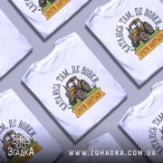 Футболка тракторист білого кольору, зображена на манекені з правого боку, фон світло-сірий, принт з жовтим трактором та написом "Катаюсь там, де вовки, срати бояться!".