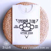 Футболка тренуй тіло, білого кольору, складена на плетеній основі, фон білий, принт чорного кольору з написами та зображенням кулака.