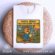 Футболка трьохфазний гумор. Біла футболка, складена на плетеній основі, з принтом бобра в синьому халаті, який виглядає стурбованим. Принт яскравий, з жовтим текстом, на фоні електричної станції.