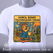 Футболка трьохфазний гумор. Біла футболка, складена на поверхні, з принтом бобра в синьому халаті, який виглядає стурбованим. Принт яскравий, з жовтим текстом, на фоні електричної станції.