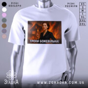 Футболка трохи божевільна, білого кольору, з прямим ракурсом, на фоні світло-сірого, з великим принтом, що зображує жінку в чорному костюмі на фоні палаючого будинку.