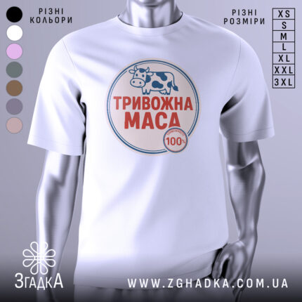 Футболка тривожна маса, біла, зображена на манекені з правого боку, фон світло-сірий, принт з коровою та написом "ТРИВОЖНА МАСА" червоного кольору.