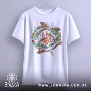 Футболка Тризуб Лелеки, біла, підвішена на вішалці, фон світло-сірий, принт з тризубом та лелеками, видно деталі малюнка.