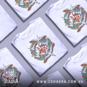 Футболка Тризуб Лелеки, біла, зображена на манекені, фон світло-сірий, принт з тризубом та лелеками в оточенні зелених рослин і квітів.