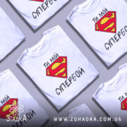 Футболка ти мій супербой, біла, з фронтального ракурсу, на манекені, з яскравим принтом у вигляді червоної літери S на жовтому фоні та текстом українською мовою.