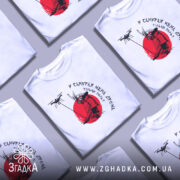 Футболка у самурая нема дрона. Біла футболка з коротким рукавом, зображення самурая на червоному фоні, принт виконаний у чорному та червоному кольорах, фон нейтральний, футболка на манекені.