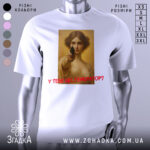 Футболка у тебе генератор. Біла футболка з принтом, на якому зображена жінка з пістолетом, знімок з фронтального ракурсу, фон нейтральний, принт яскравий, текст червоним кольором.