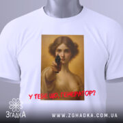 Футболка у тебе генератор. Біла футболка, складена в горизонтальному положенні, на ній принт з жінкою, що тримає пістолет, знімок з верхнього ракурсу, фон світлий, текст червоним кольором, на футболці є етикетка.