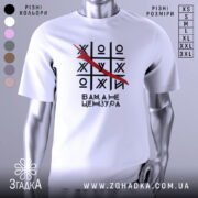 Футболка білого кольору, зображена на манекені, з принтом у вигляді гри хрестики-нулики, де червоною лінією закреслено одну з літер, текст під принтом говорить 'Вам, а не цензура'. Фон світлий, з легким градієнтом.