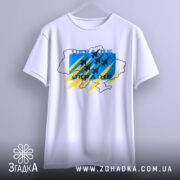 Футболка Україна авіація, біла, підвішена на вішалці, фон світло-сірий, принт з синім, жовтим та чорним кольорами, з контуром карти України та літаками.