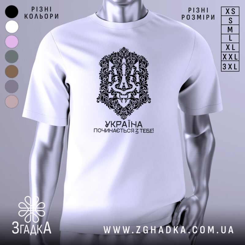 Футболка Україна починається з тебе. Біла футболка з коротким рукавом, зображена з фронтального ракурсу на манекені. На футболці чорний принт з орнаментом та написом 'УКРАЇНА ПОЧИНАЄТЬСЯ З ТЕБЕ!'