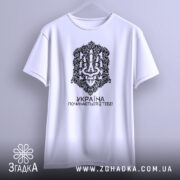 Футболка Україна починається з тебе. Біла футболка з коротким рукавом, підвішена на вішалці. Принт чорного кольору займає центральну частину, з написом 'УКРАЇНА ПОЧИНАЄТЬСЯ З ТЕБЕ!'