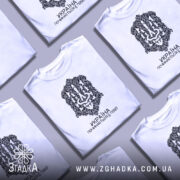 Футболка Україна починається з тебе. Біла футболка з коротким рукавом, зображена з фронтального ракурсу на манекені. На футболці чорний принт з орнаментом та написом 'УКРАЇНА ПОЧИНАЄТЬСЯ З ТЕБЕ!'