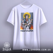 Футболка українка незламна, біла, підвішена на вішалці, фон світло-сірий, принт з жінкою в національному вбранні з автоматом, оточена вогнем і містом на задньому плані.