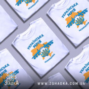 Футболка українська мрія, біла, зображена на манекені, фон нейтральний, принт з літаком та гербом України, кольори жовтий та блакитний, текст 'УКРАЇНСЬКА МРІЯ' та 'НЕЗНИЩЕННА'.