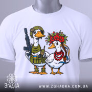 Футболка українська пара, біла, зображена зверху, фон світлий, принт з двома качками: одна в військовій формі з автоматом, інша в вінку з квітів та червоних намистин, на футболці є етикетка.