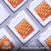 Футболка українське літо вареники, біла, зображена на манекені, фон світло-сірий, принт з варениками на решітці з сонцем на фоні.