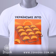 Футболка українське літо вареники, біла, складена на поверхні, фон білий, принт з варениками на решітці, тег на рукаві.