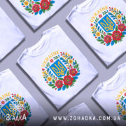 Футболка український герб, біла, зображена з фронтального ракурсу на манекені, фон світло-сірий, принт містить герб України в синьому квадраті оточений кольоровими квітами.