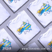 Футболка український хіпстер, біла, зображена на манекені з правого боку, фон нейтральний, принт з веселим персонажем у жовто-блакитному вбранні, напис "100% українським хіпстер".