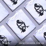 Футболка український козак, біла, зображена на манекені, фон світло-сірий, принт чорного кольору з зображенням козака з характерною зачіскою та серйозним виразом обличчя.