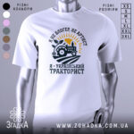 Футболка український тракторист, білого кольору, зображена на манекені, фон світло-сірий, принт з трактором, сонцем і рослиною, текст чорного кольору.