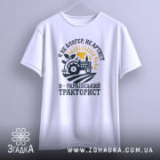 Футболка український тракторист, білого кольору, зображена на манекені, фон світло-сірий, принт з трактором, сонцем і рослиною, текст чорного кольору.