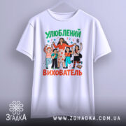 Футболка улюблений вихователь, білого кольору, зображена на манекені, фон світло-сірий, принт з персонажами, що святкують, з яскравими кольорами та написом 'Улюблений вихователь'.
