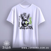 Футболка урбан стиль, біла, зображена з фронтального ракурсу, фон світлий, принт з чорним смайлом з вухами зайця, зеленими краплями фарби та написом 'NEW YORK'.