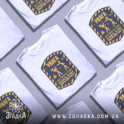 Футболка увага про роботу, біла, зображена на манекені, фон світло-сірий, принт у жовто-синіх тонах з написом 'УВАГА' та ілюстрацією двох фігур.