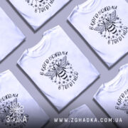 Футболка в кого бджоли, біла, зображена з правого ракурсу на манекені, фон світлий, принт з бджолою та написом вгорі і внизу.